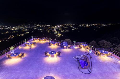 un gran patio con mesas y sillas por la noche en Sky Garden Resort, en Dhulikhel