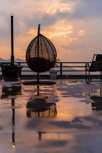 an umbrella sitting on top of a patio with the sunset at Sky Garden Resort in Dhulikhel