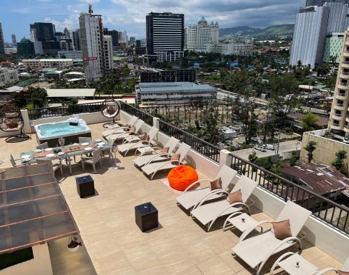 einen Balkon mit Liegestühlen und einem Pool auf einem Gebäude in der Unterkunft 88th Avenue in Cebu City