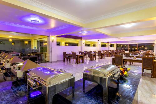 a restaurant with tables and chairs and purple lighting at Sky Garden Resort in Dhulikhel