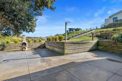 an outdoor patio with a brick wall and a fireplace at Beachfront Favourite - Foxton Beach Holiday Home in Foxton Beach