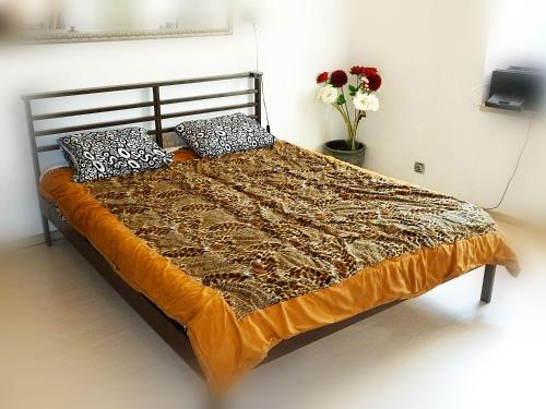 a large bed in a room with flowers on it at Ditton apartment city center in Daugavpils