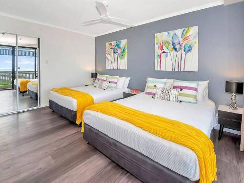 a bedroom with two beds with yellow blankets at 'Luxury Waterfront' Spectacular Oasis in the City in Cairns