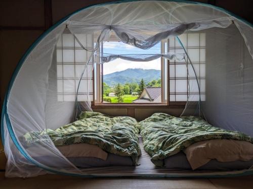 Cama en habitación redonda con ventana en Lien Tono - Vacation STAY 85593v en Tōno