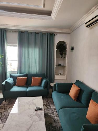 布拉薩維爾的住宿－appartement nid，客厅配有2张蓝色的沙发和1张桌子