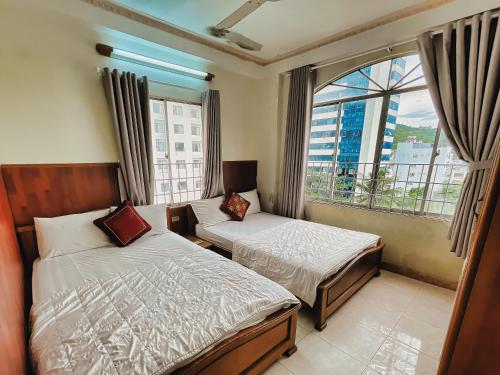 1 Schlafzimmer mit 2 Betten und einem großen Fenster in der Unterkunft Quang Vinh 2 Hotel in Nha Trang