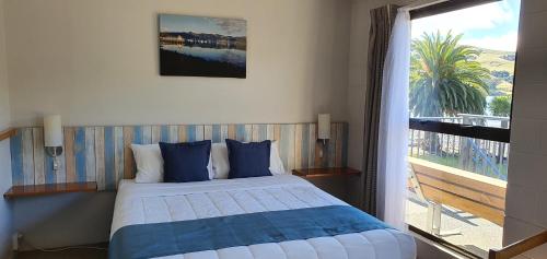 a bedroom with a bed and a large window at Akaroa Waterfront Motels in Akaroa