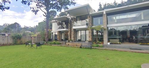 a large house with a lawn in front of it at Mountain Retreat Kodai in Kodaikānāl