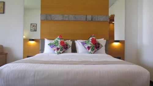 a bedroom with a large white bed with two pillows at Mountain Retreat Kodai in Kodaikānāl