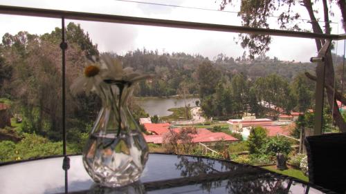 a vase with a flower sitting on a window sill at Mountain Retreat Kodai in Kodaikānāl