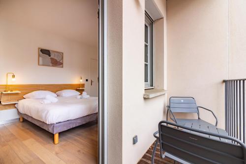 トゥールーズにある404 · Wonder Appart - Vue Garonne -のベッドルーム1室(ベッド1台、椅子1脚付)