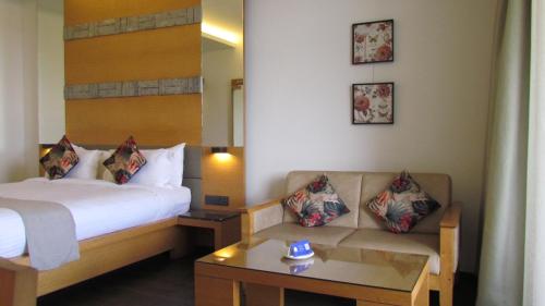a hotel room with a bed and a couch at Mountain Retreat Kodai in Kodaikānāl