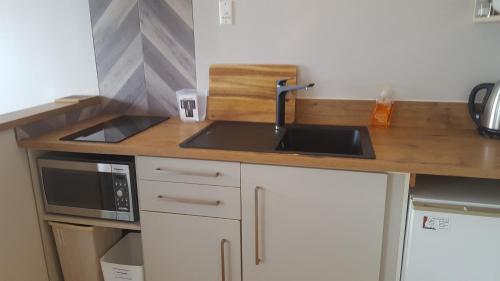 a kitchen with a sink and a microwave at Akaroa Waterfront Motels in Akaroa