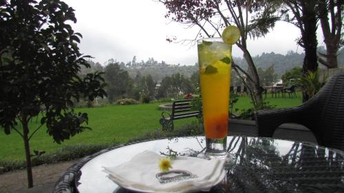 a drink sitting on top of a table with a plate at Mountain Retreat Kodai in Kodaikānāl