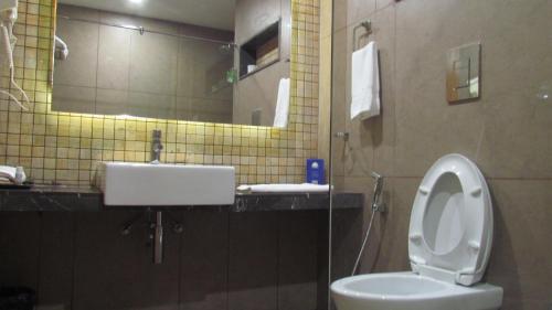 a bathroom with a sink and a toilet and a mirror at Mountain Retreat Kodai in Kodaikānāl