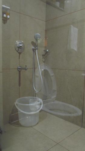 a bathroom with a shower with a toilet and a bucket at Mountain Retreat Kodai in Kodaikānāl