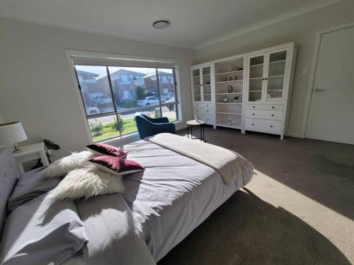 1 dormitorio con cama grande y ventana grande en 5 bedroom new house (no stairs), en Marsden Park