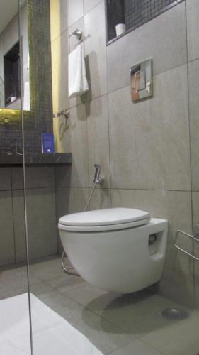 a bathroom with a toilet and a glass shower at Mountain Retreat Kodai in Kodaikānāl