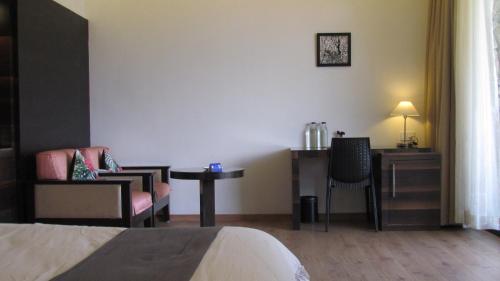 a hotel room with a bed and a desk and a chair at Mountain Retreat Kodai in Kodaikānāl