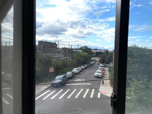 a view from a window of a street with cars at 2BR elevator APT 10min to LGA airport 1min to train! in Queens