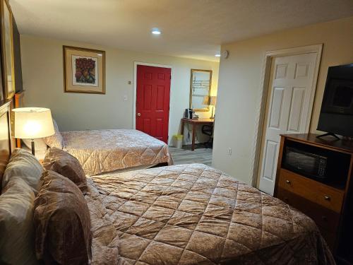 a hotel room with two beds and a red door at Stardust Motel in Duncannon