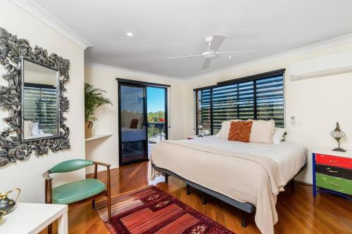 a bedroom with a bed and a large window at Angel's Beach Hidden Oasis in East Ballina