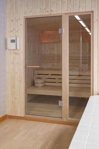 a wooden cabinet with glass doors in a room at Hotel Castellon Center Affiliated by Meliá in Castellón de la Plana