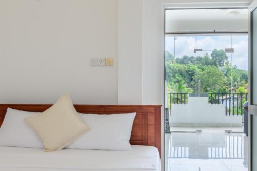 a bedroom with a bed and a large window at Pavulak in Weligama