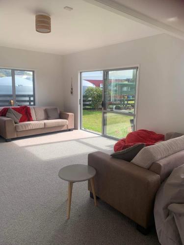 a living room with a couch and a table at Hosts on the Coast Catch of the Day in Cooks Beach