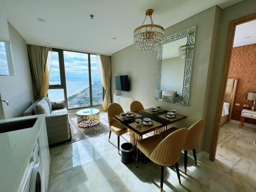 a living room with a table and chairs and a dining room at Copacabana Jomtien Beach Condo 中天海滩寇芭酒店公寓 in Jomtien Beach