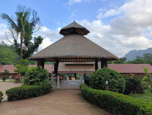 un pavillon avec un toit de paille dans un parc dans l'établissement SAIYOK MANTRA RESORT : ไทรโยค มันตรา รีสอร์ท, à Ban Huai Maenam Noi