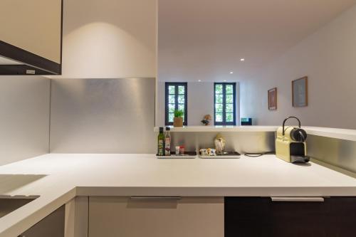 een keuken met een wit aanrecht en een wastafel bij 403 · Wonder Appart' - Vue sur Garonne - in Toulouse