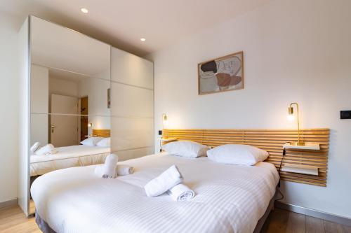 2 camas en una habitación con paredes blancas y espejos en 403 · Wonder Appart' - Vue sur Garonne -, en Toulouse