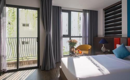 a bedroom with a large bed and a balcony at Aaron Boutique Hotel in Nha Trang