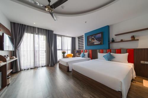 a hotel room with two beds and a desk at Aaron Boutique Hotel in Nha Trang