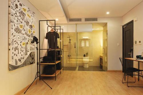 een kamer met een badkamer met een toilet en een glazen deur bij The Hammock Hotel Ben Thanh in Ho Chi Minh-stad