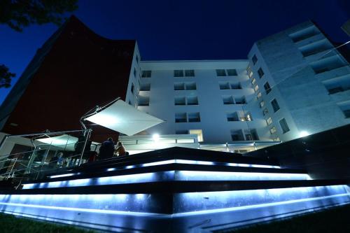 a group of people standing in front of a building at night at Giulivo Hotel & Village in Baia Domizia