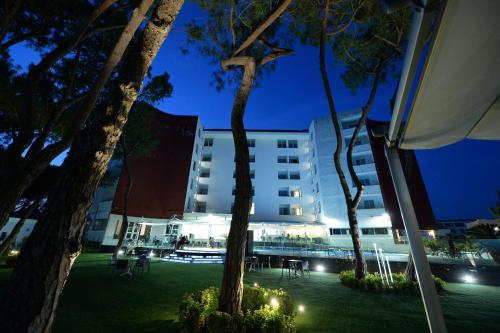 a building at night with trees in front of it at Giulivo Hotel & Village in Baia Domizia