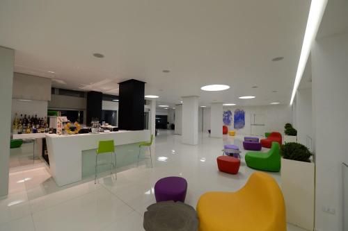 a lobby with colorful chairs and a counter at Giulivo Hotel & Village in Baia Domizia