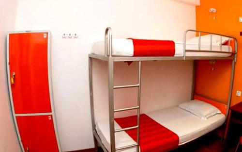 2 łóżka piętrowe w pokoju z czerwono-białym w obiekcie CityRest Fort w Kolombo