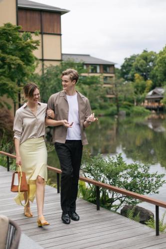 a man and a woman walking down a bridge at Four Seasons Hotel Kyoto in Kyoto