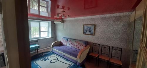 a living room with a purple couch and a window at квартира по Гумарова in Atyrau