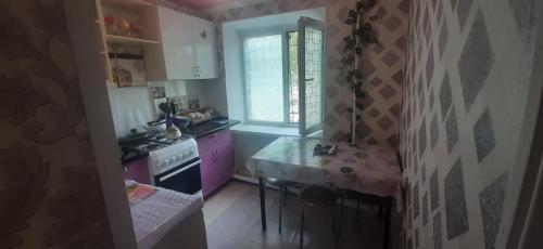 a small kitchen with a stove and a sink at квартира по Гумарова in Atyrau