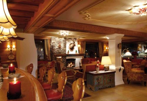 a living room with a fireplace and a table and chairs at Sporthotel Lorünser in Zürs am Arlberg