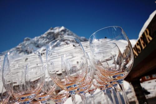 a row of wine glasses with a mountain in the background at Sporthotel Lorünser in Zürs am Arlberg