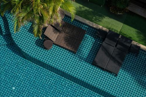 an overhead view of a swimming pool with palm trees at Guuden Huahin Hotel in Hua Hin