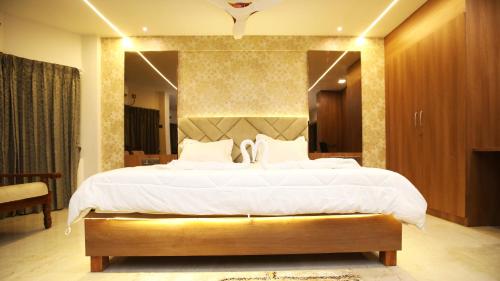 a bedroom with a large bed and a large mirror at Hotel TamilNadu, Kancheepuram in Kanchipuram