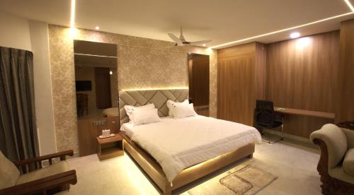 een slaapkamer met een groot wit bed in een kamer bij Hotel TamilNadu, Kancheepuram in Kanchipuram
