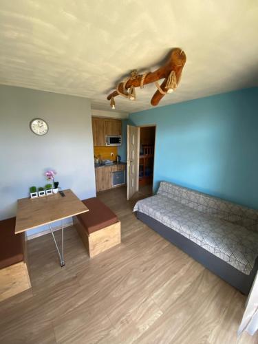 a living room with a bed and a table at Morska Bryza in Chłopy