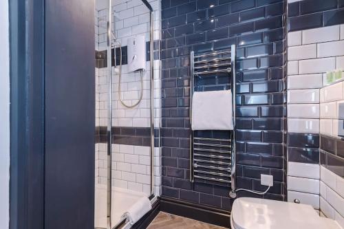 a bathroom with a blue and white tiled wall at Supersized Studio in Chester in Chester